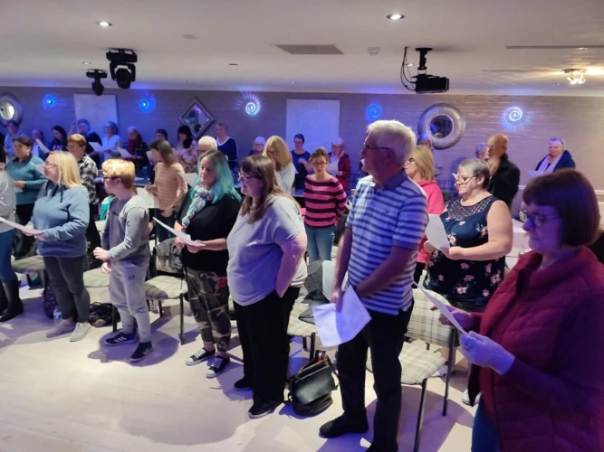 A group of Singergie members at a rehearsal